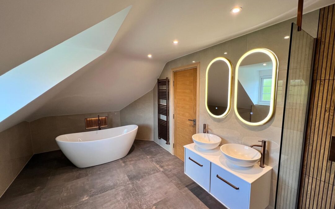 Modern Essex bathroom with bath, double sinks, lit mirror, and large shower installation